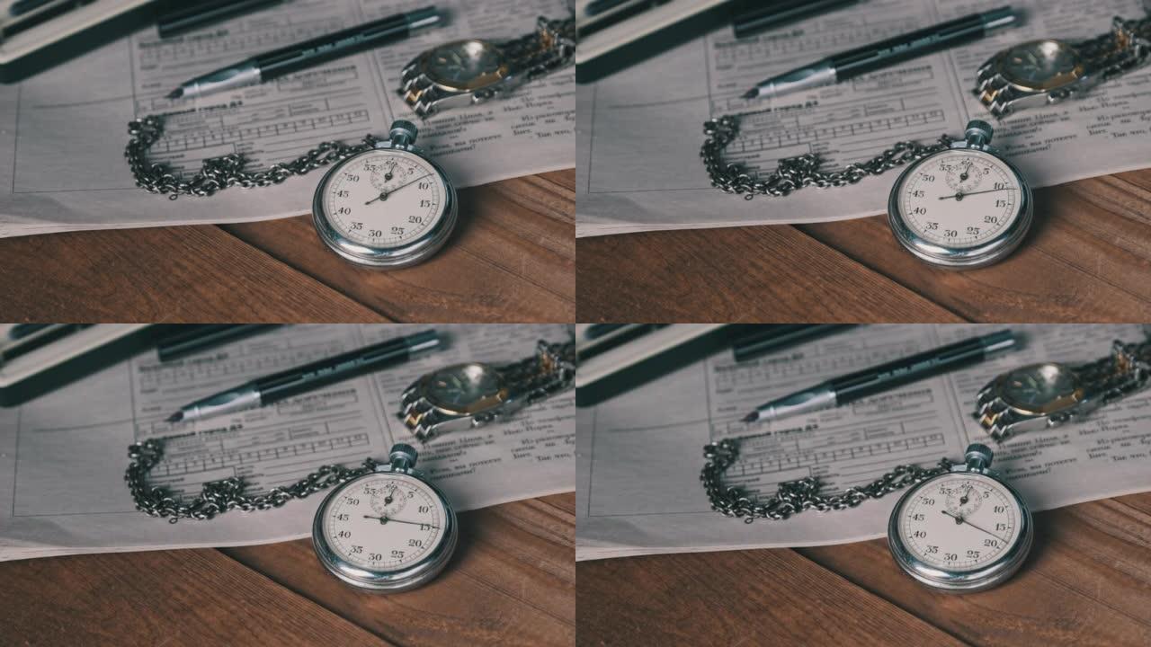 古董秒表躺在木制桌子上，上面放着旧文件，数秒