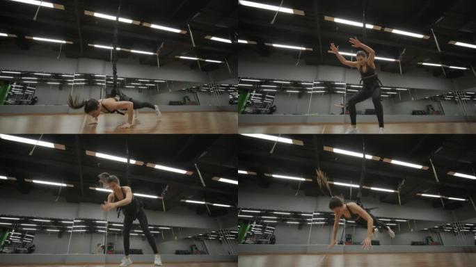 女人通过蹦极训练在健身房锻炼，做困难的锻炼，蹦极健身，现代运动