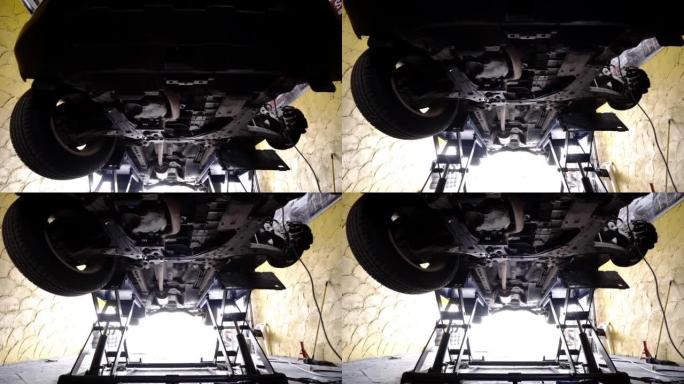 汽车修理厂液压支架上的汽车低角度视图。