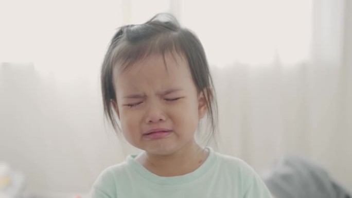 亚洲小女孩在家里的房间里哭泣