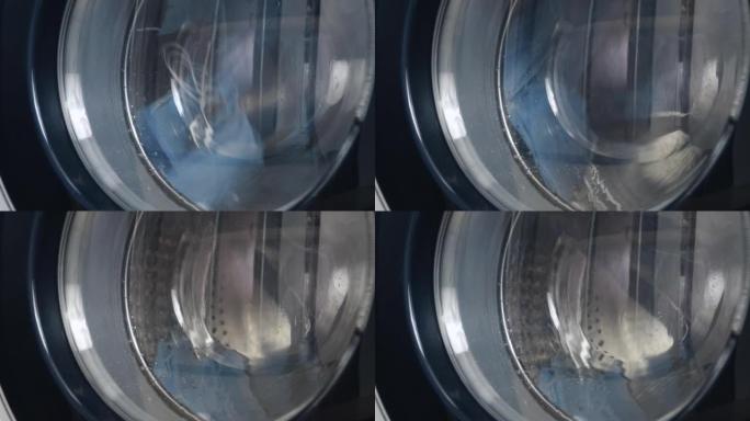 洗衣机洗脏医用口罩。旋转滚筒洗衣机的特写视频