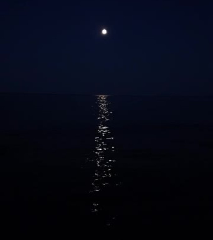 慢动作在海水下拍摄银色月光，月球路径从地平线到海岸。小浪到达岸边。旅游假期和假期暑期概念与复制空间。