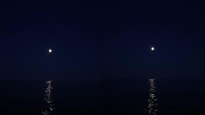 慢动作在海水下拍摄银色月光，月球路径从地平线到海岸。小浪到达岸边。旅游假期和假期暑期概念与复制空间。