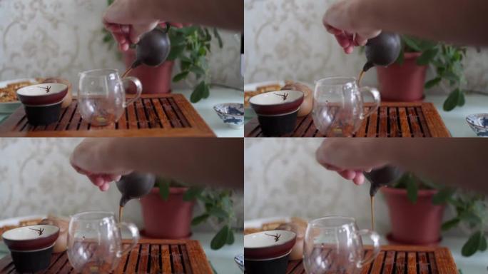 便携式桌子上的茶道。沥干第一杯啤酒，冲洗茶。在中文中，四茶，洗涤，它去除茶叶表面的杂质，以充分发挥香