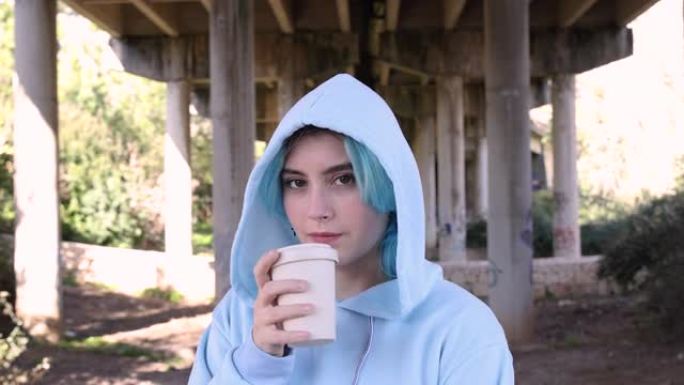 穿着超大连帽衫的蓝发少女喝咖啡对着桥柱