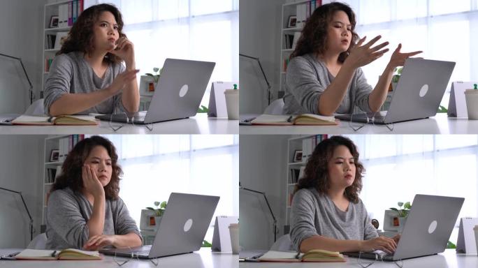 感到疲倦和压力。年轻的亚洲妇女坐在办公室里用笔记本电脑工作时，思想深处疲惫不堪。