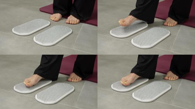女性脚特写踩在指甲上。站在钉子上。瑜伽的精神实践。