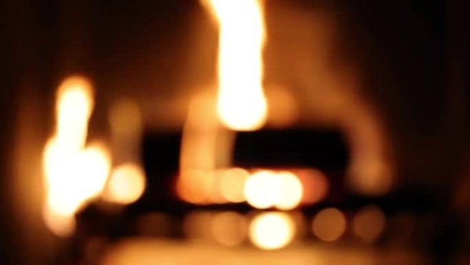 火灾日志在家庭壁炉中燃烧，散焦模糊的背景。房子里的烟囱着火，冬天变暖的背景。