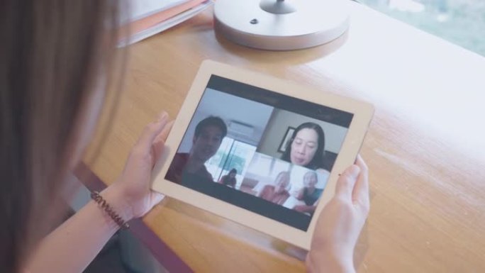女人使用数字平板电脑和手机与家人进行社交电话会议