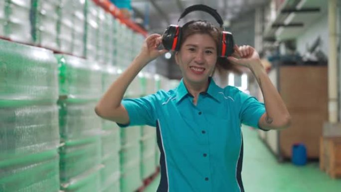 肖像女性亚洲中国仓库工厂前护耳器看着相机做脸