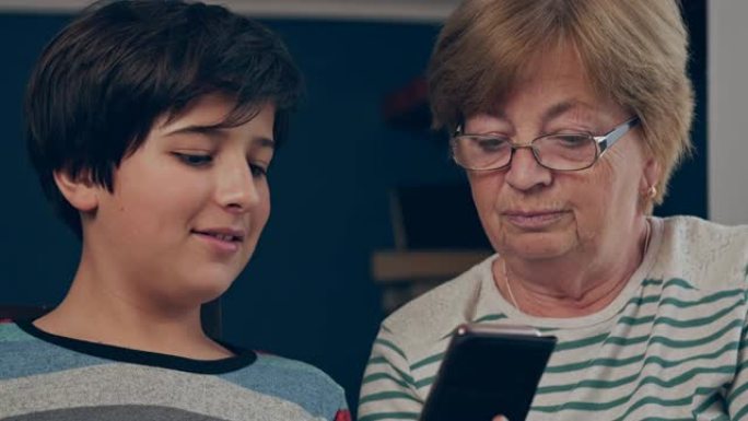 孙子教他的祖母使用智能手机。老一代人掌握小玩意。