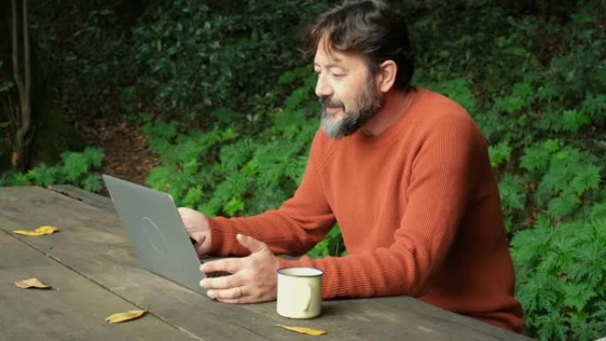 一名男子在户外使用在线连接和笔记本电脑工作的侧视图。无线和漫游互联网wifi连接以及使用技术进行在线