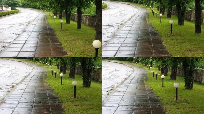 4k视频，人行道上的混凝土板被雨水弄湿，在城市公园阴雨多雨的夏日，沿着小巷的灯笼和树木，相机变焦