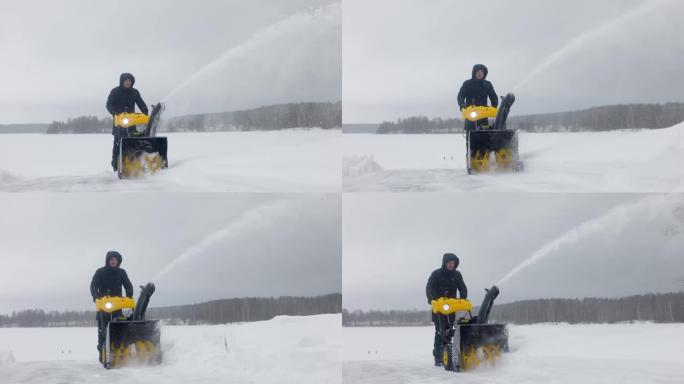 大雪过后，男人用木屋的扫雪机清理积雪。前视图。慢动作