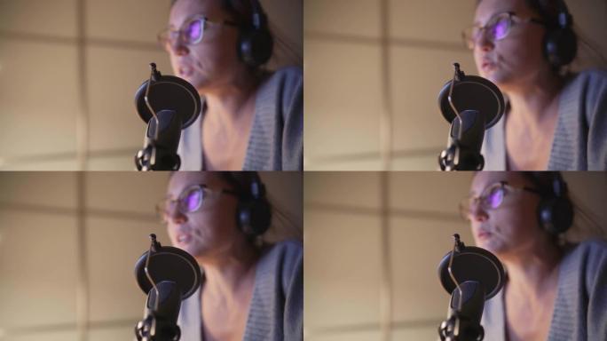 带流行滤镜的麦克风特写4k视频，带耳机的年轻女性使用带音乐创作工作室应用的台式电脑录制语音。现代家庭
