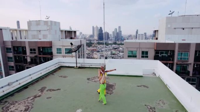 在城市屋顶上绿色和黄色跳舞的模型的无人机拍摄
