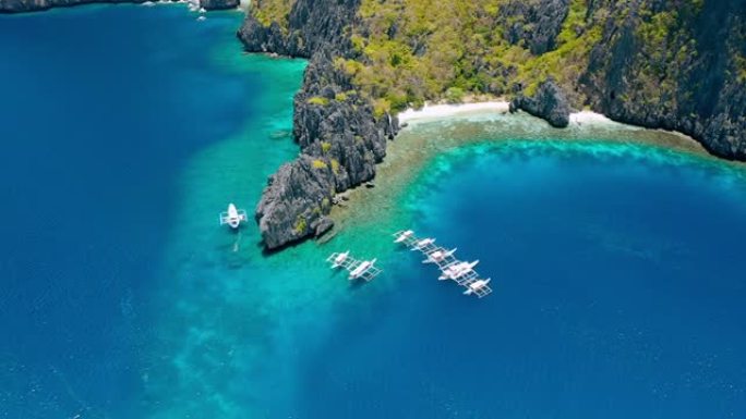 停泊在Miniloc岛秘密泻湖附近的潜水船的鸟瞰图。巴拉望爱尼多。菲律宾。奇异的石灰岩岩层和带有珊瑚