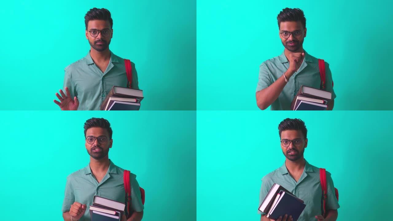 印度学生男子看着相机感到高兴，戴着眼镜和橙色背包，在蓝色工作室里谈论认知书籍