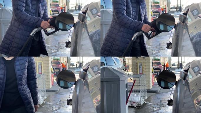冬季，一个人关闭汽车上油箱加油口颈的车门弹簧外壳口袋。概念: 汽油价格。