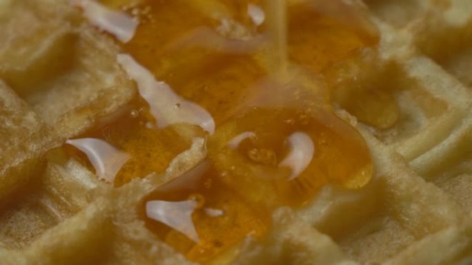 将枫糖浆倒在美味的比利时金华夫饼上