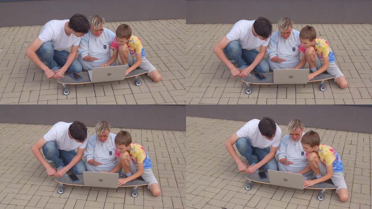 坐在人行道上使用长板笔记本电脑。现代青年交流