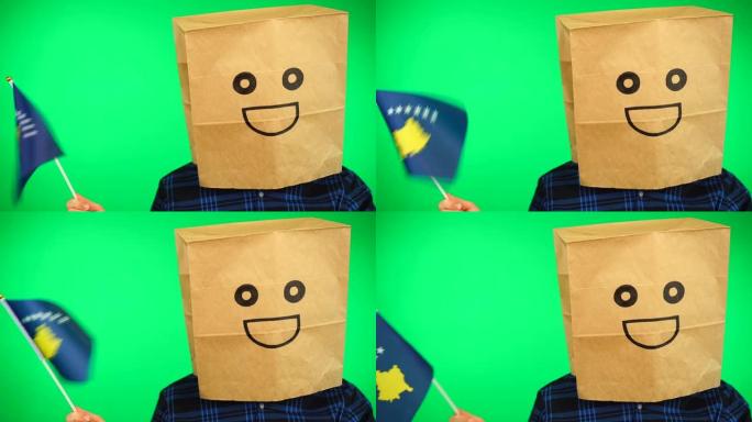 人头戴纸袋的男子肖像，在绿色背景下挥舞科索沃国旗，面带微笑。