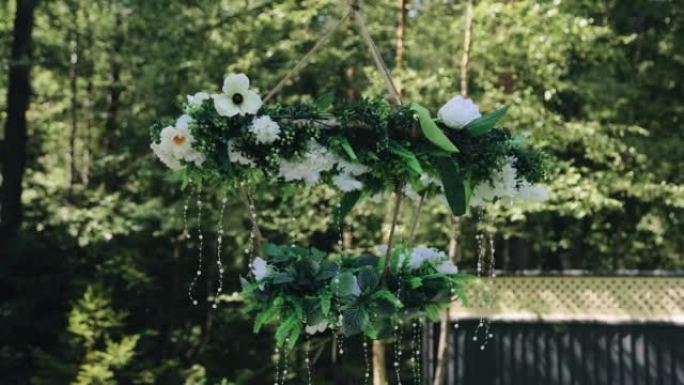 鲜花制成的装饰性吊灯装饰着大自然中的院子空间。非常酷的自然