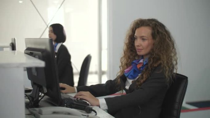 在机场用电脑值机柜台的女人