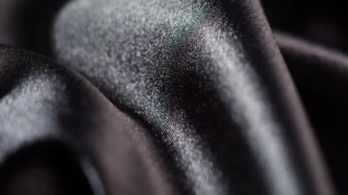 黑色丝绸特写，深色缎面奢华布料纹理背景。豪华设计纺织品