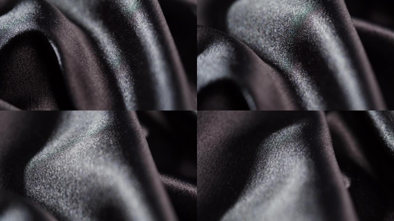 黑色丝绸特写，深色缎面奢华布料纹理背景。豪华设计纺织品