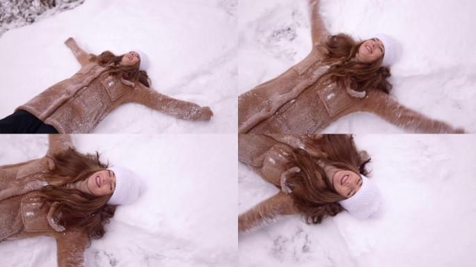 一个年轻的女人在雪地里做天使