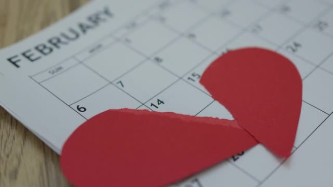 两个红色的一半纸心掉下来2月月日历。情人节