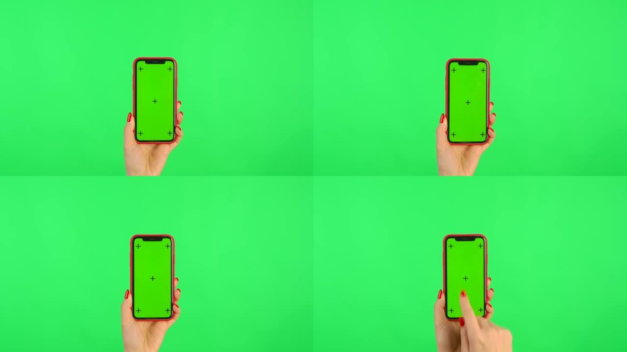 女人拿着绿色背景上带有工作区模拟屏幕的手机。女性手触摸，点击，点击，滑动，滑动，放大，缩小。广告区域
