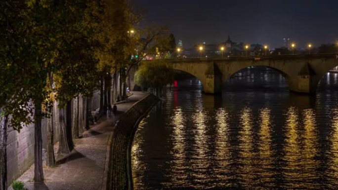 塞纳河码头在巴黎人民步行桥的夜晚灯光和倒影