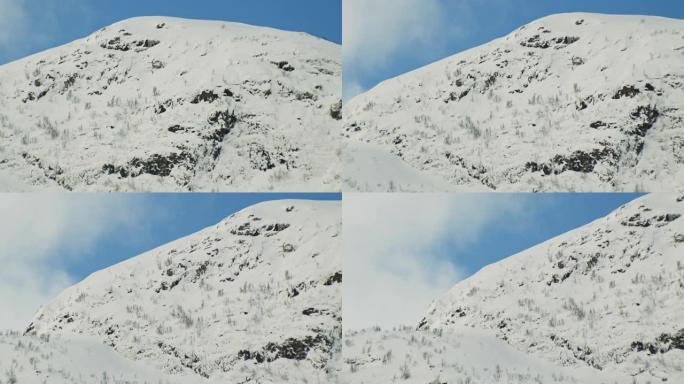 积雪覆盖着树木和岩石的山坡