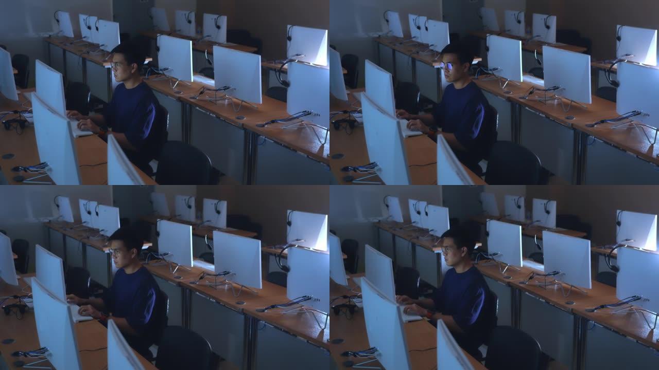 亚洲人在机房办公室工作到很晚时使用计算机编码计算机程序，程序员和黑客概念