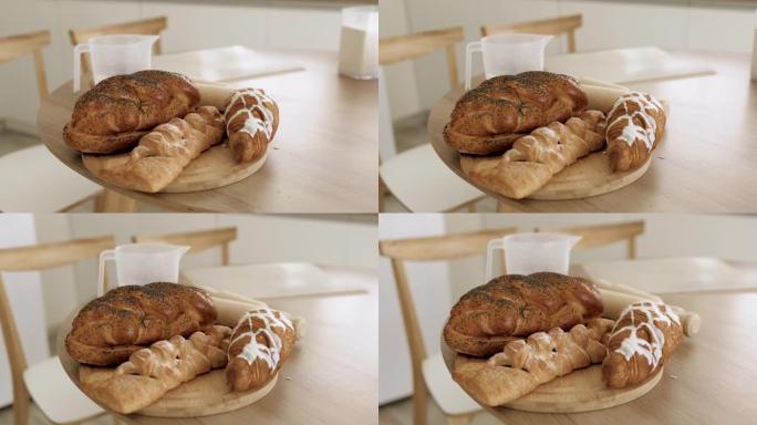 不同品种的新鲜出炉的面包躺在厨房桌子上的木板上。