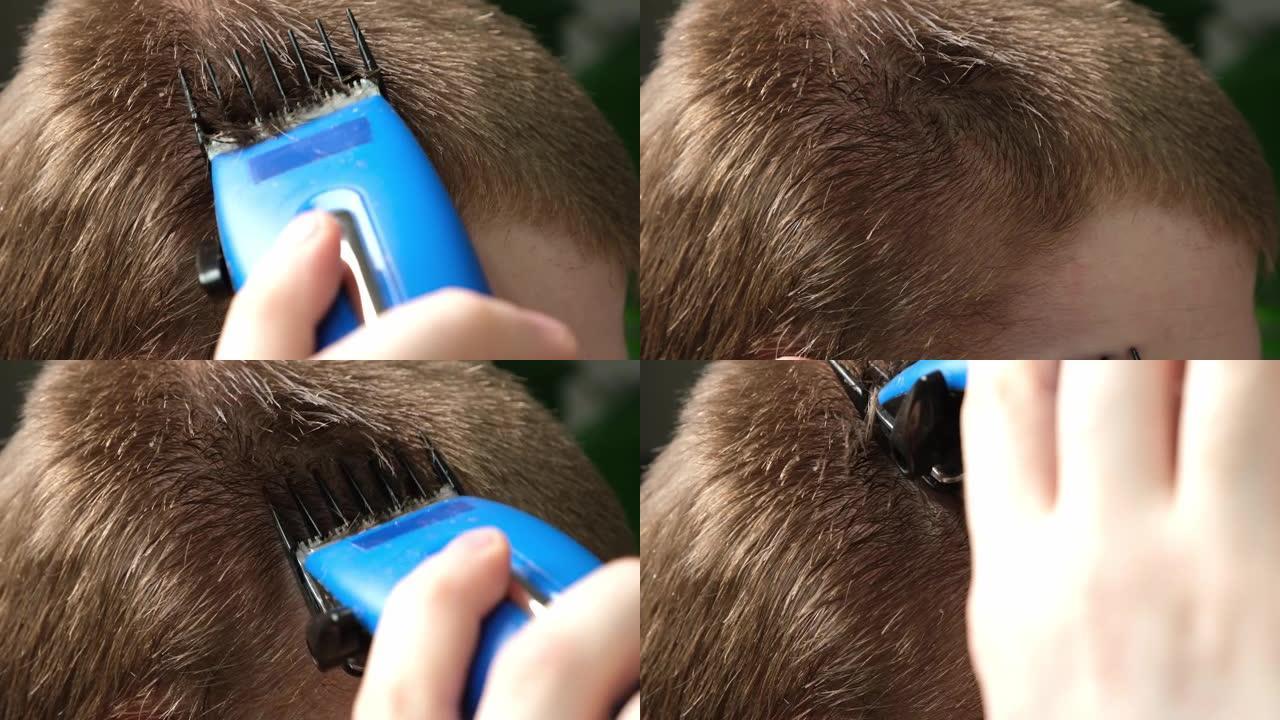一个男人正在家里用电动理发推子理发。家庭理发。理发师的积蓄。