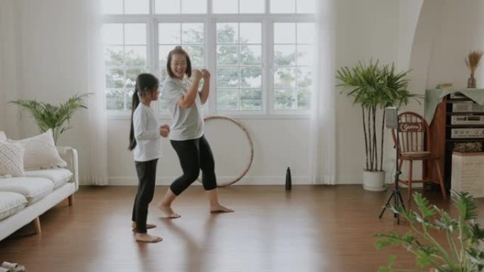 妈妈和女儿的活动在家享受有氧舞蹈在线课。