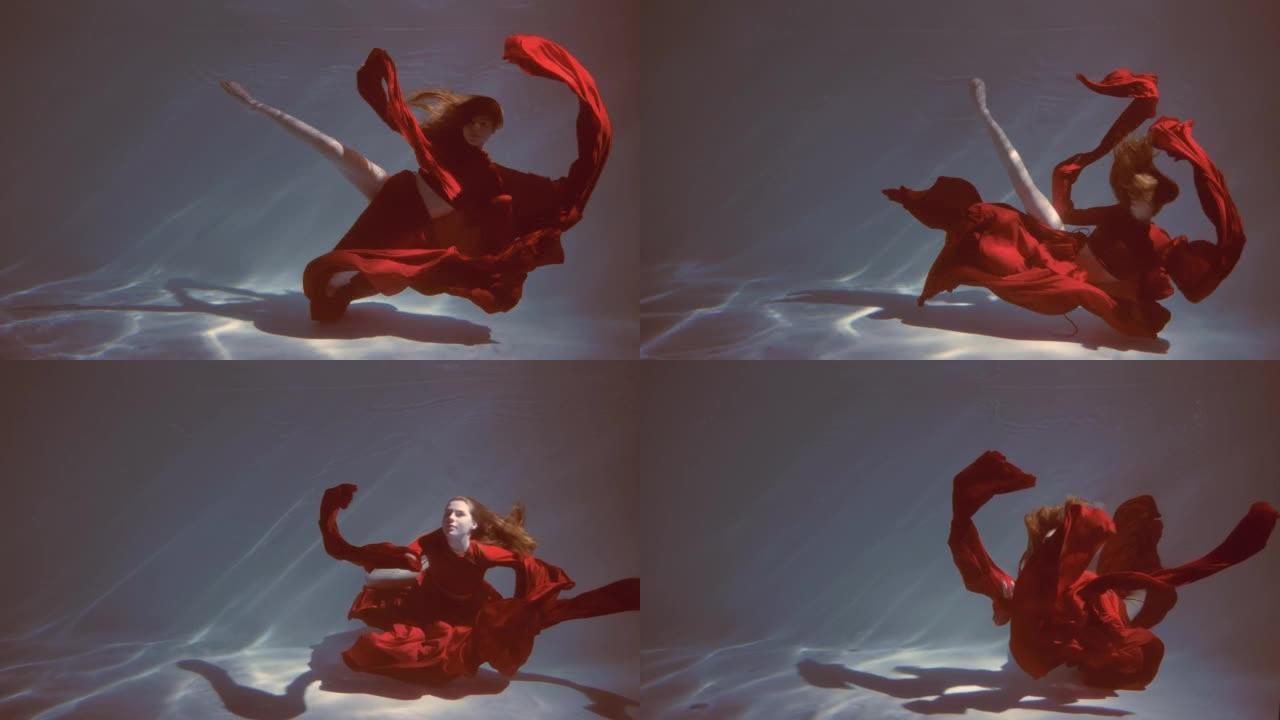 迷人的红发年轻女子穿着红色连衣裙美丽地在水下游泳。慢动作