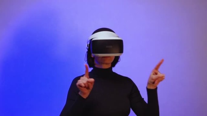 一个戴着虚拟现实头盔的女孩张开双臂，好像在推动空间，紫色霓虹灯，全高清。虚拟宇宙的概念。虚拟空间中的