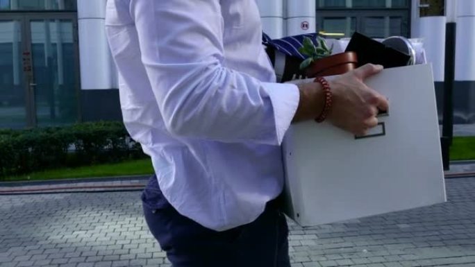 一个男人从办公室提着一个大盒子