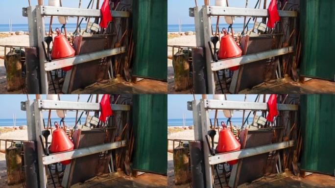 渔具浮标网标记旗及筛子存放于港口渔人棚外