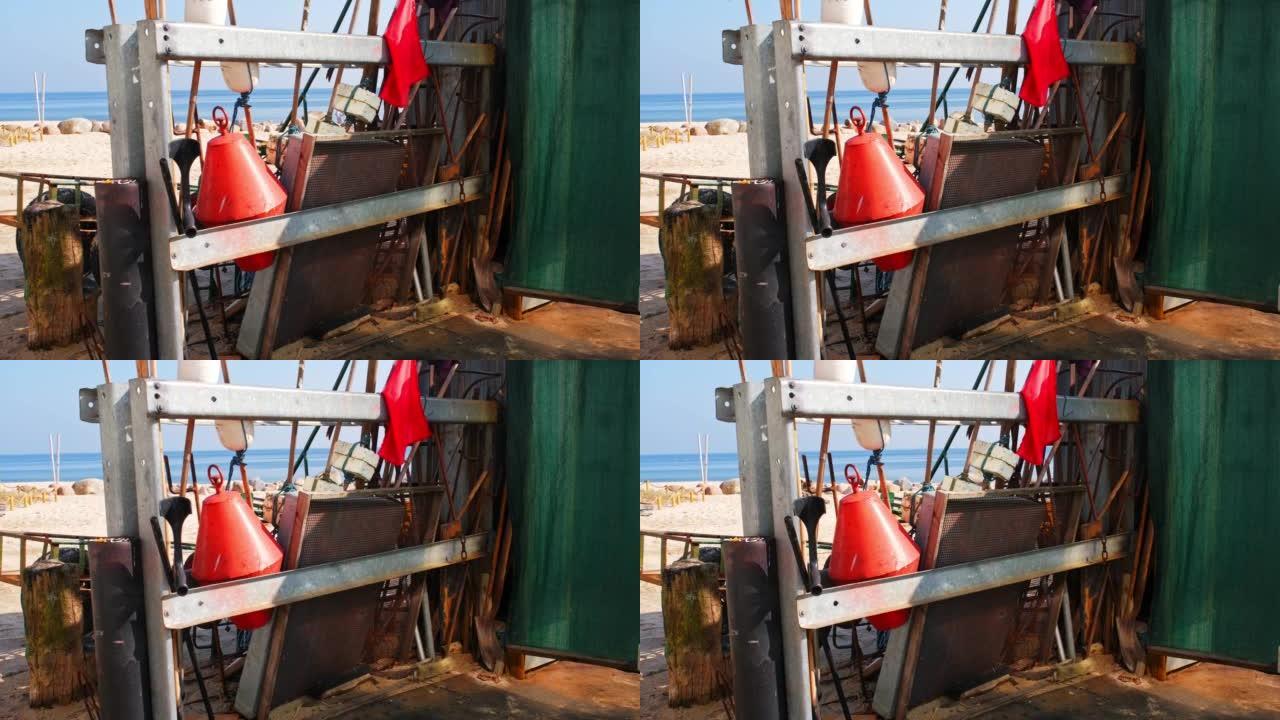 渔具浮标网标记旗及筛子存放于港口渔人棚外