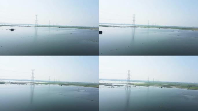 无人机拍摄的农田因大雨被水淹没，农田里的高压电塔。