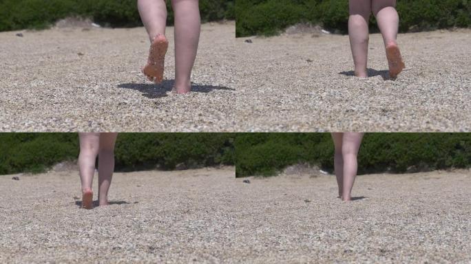 脚女人在砾石海滩上行走，它湿着脚，走路时摔倒