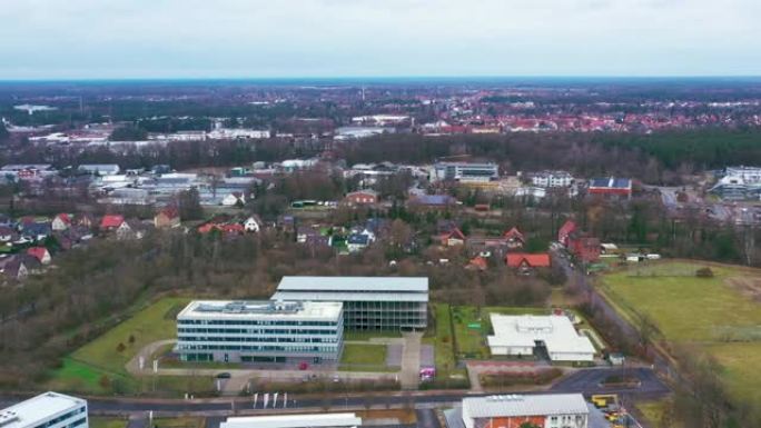 从德国吉夫霍恩市南部边缘的鸟瞰图，显示了带有大型商业建筑的新工业园区后面的单户住宅的发展