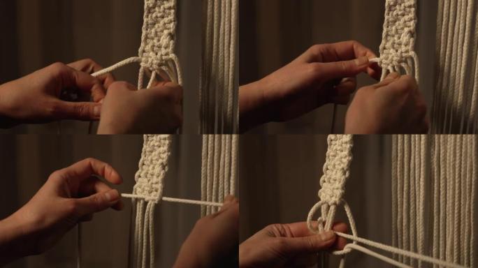 一个女人在创意车间制作绳索工艺。女人的手在花边线上打结，创造一个创造性的蕾丝装饰。编织波西米亚风格的