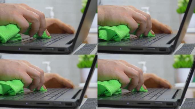 办公室男性工人使用喷雾消毒凝胶消毒擦拭笔记本电脑键盘