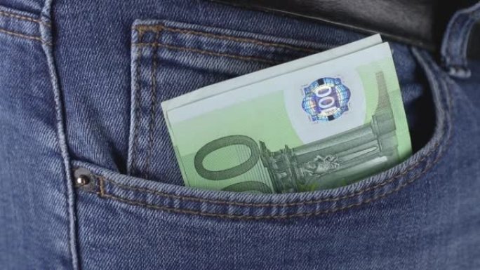 男子把一包欧元货币现钞放在蓝色牛仔裤的口袋里特写。价格上涨或财务成功的概念